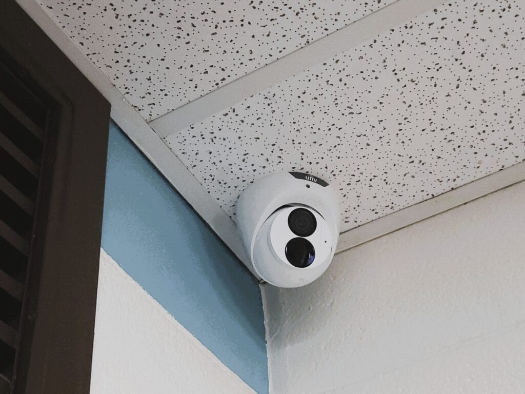 Dome camera mounted above a dark wood door frame